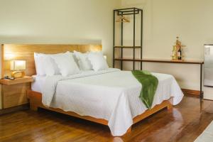1 dormitorio con 1 cama grande con sábanas blancas en El Edén Country hotel y Club Residencial, en Armenia