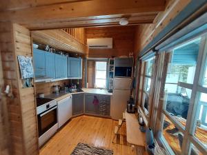 a kitchen in a tiny house with blue cabinets at Villa kitkanhelmi in Kuusamo
