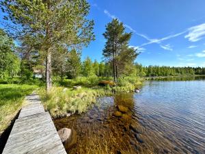 un pont en bois sur une masse d'eau dans l'établissement Villa kitkanhelmi, à Kuusamo