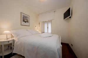 a bedroom with a white bed and a television at Central Square "Stone Pearl Heritage" Luxury Suite in Split