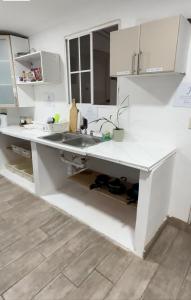 a kitchen with white counters and a sink at Hostal Villa Marta in Santa Ana