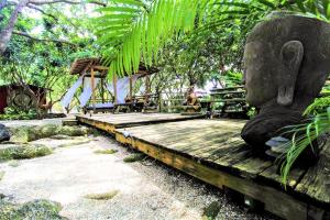 eine Statue eines Elefanten auf einer Holzbank in der Unterkunft Bird Tiny House in Charming Japanese Garden in Homestead