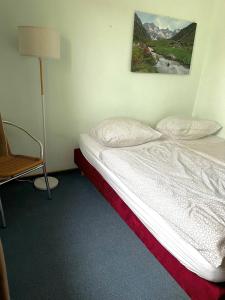 a bedroom with a bed and a chair and a picture on the wall at Panoramic Aparthotel in Braunlage