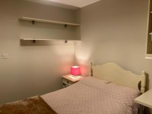 a bedroom with a bed and a nightstand with a pink lamp at Valley view in Gort