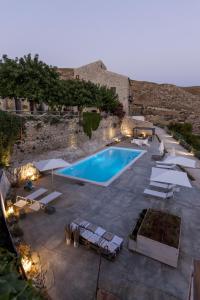 a swimming pool with chairs and umbrellas around it at Masseria Agnello in Realmonte
