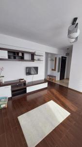 a large living room with a wooden floor and white walls at Apartament Râșnov in Râşnov