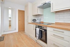 a kitchen with white cabinets and a microwave at Lancaster House in Stoke on Trent