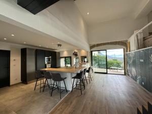 Una cocina con una gran mesa y sillas de madera. en Moderne corps de ferme - Piscine, en Grésy-sur-Aix