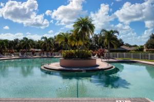 een groot zwembad met palmbomen op de achtergrond bij Blue Heron House! Cozy home with heated pool and pool toys! Water view out back! in Bradenton