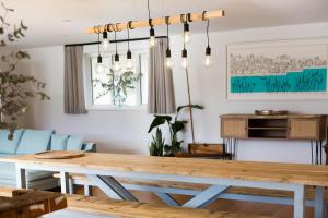 a dining room with a wooden table and blue chairs at Seaflowers in Kingsbridge