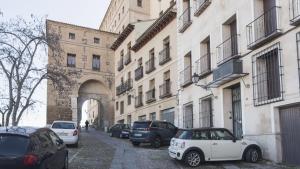 un groupe de voitures garées dans une rue à côté des bâtiments dans l'établissement Apartamentos Zocosol by Toledo AP, à Tolède