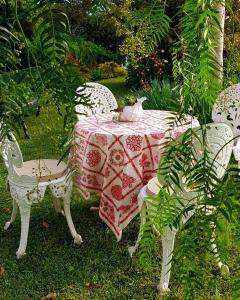 une table et des chaises avec un tissu de table rouge et blanc dans l'établissement Quinta do Cabouco, à Ribeira Brava
