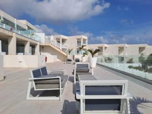 eine Reihe von Liegestühlen auf dem Dach eines Gebäudes in der Unterkunft Luxury Sea View Senator Lanzarote in Costa Teguise