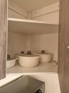tres tazones sentados en un estante en una cocina en EAGLE WEAVERS NEST, en Livingstone