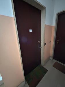 una puerta negra en una habitación con una alfombra verde en Kibilù - Via Quattro Novembre, en Corsico