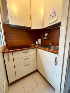 una pequeña cocina con armarios blancos y fregadero en Kibilù - Via Quattro Novembre en Corsico