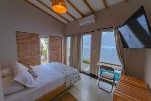 a bedroom with a large bed and a flat screen tv at Colonial Beach Airport Hotel in Cartagena de Indias