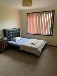 Un dormitorio con una cama grande y una ventana en G.Villa King Bedroom Adjacent to Parks and Bus Stations en Melbourne
