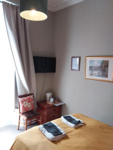 una camera con letto, sedia e scrivania di The City Braveheart a Edimburgo
