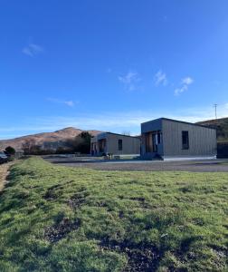 a couple of buildings with a field in the foreground at Angusfield Cabins in Sconser