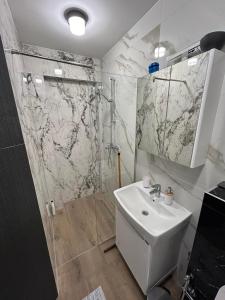 y baño con lavabo blanco y ducha. en Villa Mešić, en Stojčevac