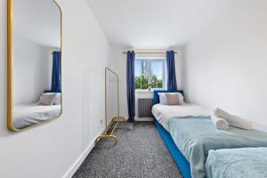 una camera con due letti e uno specchio di Spacious 2 bedroom flat by Zen Abodes Short Lets & Serviced Accommodation with Free Parking & Free Wifi a Watford