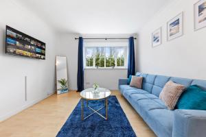 a living room with a blue couch and a table at Spacious 2 bedroom flat by Zen Abodes Short Lets & Serviced Accommodation with Free Parking & Free Wifi in Watford