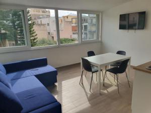 ein Wohnzimmer mit einem blauen Sofa und einem Tisch in der Unterkunft GIANGY HOME in Casteldaccia