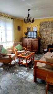 sala de estar con muebles y pared de piedra. en Apartamentos Rurales Casa el Abad en San Pelayo de Tehona