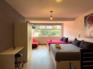 a room with a bed and a couch and a table at Loft moderno con dos camas king en Zona Boulevard in Morelia