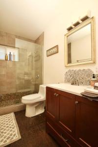 a bathroom with a toilet and a sink and a mirror at Mayfair House - 4 Minutes to National Park! in Twentynine Palms +18 photos