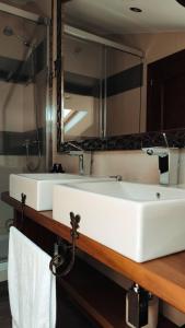 a bathroom with two sinks and a large mirror at Apartamentos Rurales Casa el Abad in San Pelayo de Tehona