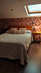 um quarto com uma cama e uma clarabóia em Apartamentos Rurales Casa el Abad em San Pelayo de Tehona