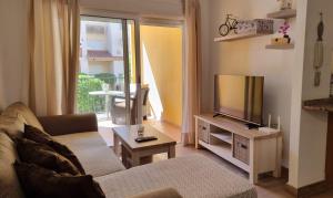 een woonkamer met een bank en een televisie bij Apartment Albir Playa Florida in Albir