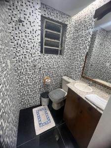 y baño con lavabo, aseo y espejo. en Cobertura central /com ar, en Caxias do Sul