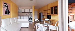 a living room with a white couch and a table at Apartamentos Zenit Mar in Noja