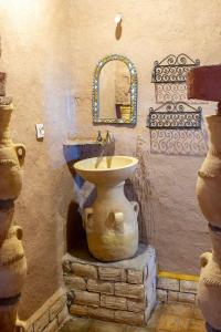 La salle de bains est pourvue d'un lavabo en pierre et d'un miroir. dans l'établissement kasbah hotel Luna, à Erfoud