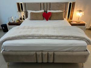 Una cama grande con un corazón rojo. en holiday beach Ajman fantastic Seaview beautiful Terrace Master bedroom attach bath شاطئ العطلات عجمان إطلالة رائعة على البحر وشرفة جميلة وحمام ملحق بغرفة النوم الرئيسية en Ajman 