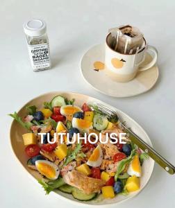 a plate of fruit salad with a cup of coffee at TUTUhouse in Cairo