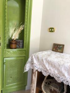 a green cabinet with a table in a room at TUTUhouse in Cairo