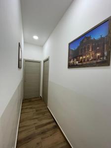 een hal met witte muren en een schilderij aan een muur bij Calabrò 21 Appartament in Catania