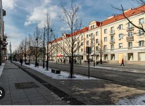 a city street with buildings and trees in the snow at Mieszkanie w Centrum in Białystok