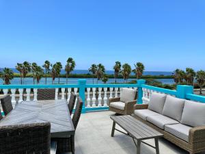 a patio with a table and chairs on a balcony at MERAKII SEAVIEW ESCAPE CURACAO in Willemstad