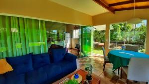 ein Wohnzimmer mit einem blauen Sofa und einem Tisch in der Unterkunft Solar dos Ventos in Alto Paraíso de Goiás + 7 Fotos