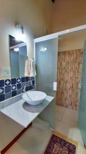 ein Badezimmer mit Waschbecken und Glasdusche in der Unterkunft Solar dos Ventos in Alto Paraíso de Goiás