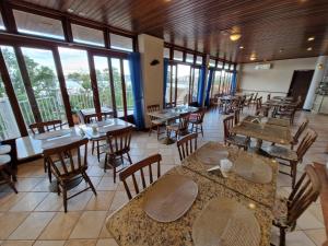 a restaurant with tables and chairs and windows at HOTEL DAIFA in Florianópolis