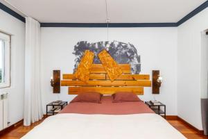 Un dormitorio con una cama grande y una lámpara de araña. en A Tranquilidade do Campo - Villa em exclusividade, en Sesimbra