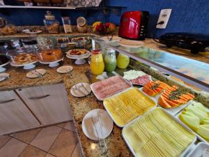a buffet with different types of food on a counter at HOTEL DAIFA in Florianópolis