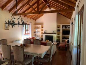 a dining room with a table and a living room at Casa con piscina y gran parque en Los Cardales in Los Cardales