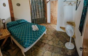 a bedroom with a bed and a fan at Caracolito in Las Peñitas